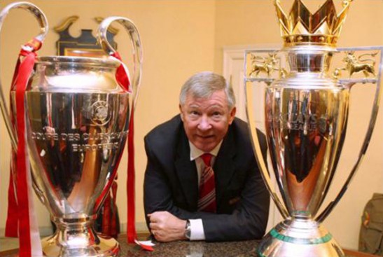 Sir Alex Ferguson with Champions League and English Premier League trophies